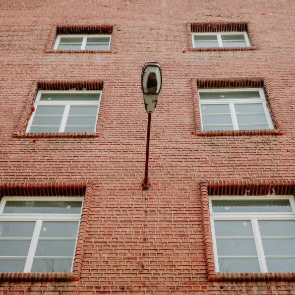 Brick building facade with windows and a lamp.